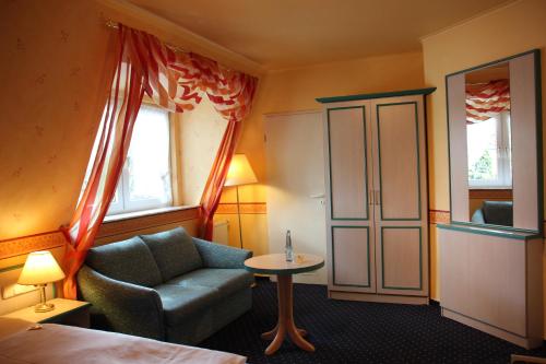 a hotel room with a chair and a table at Hotel Nordic in Norderstedt