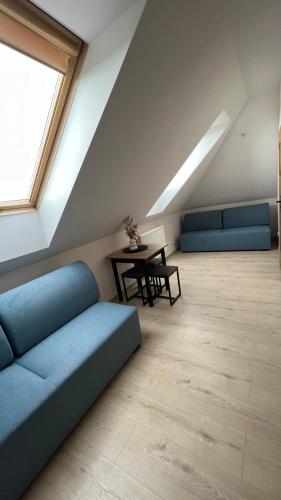 a living room with a blue couch and a table at Kraken-pokoje gościnne in Krynica Morska