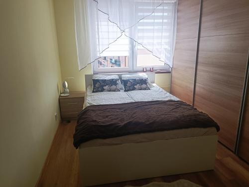a small bedroom with a bed with a window at PRZYTULNE MIESZKANIE in Borne Sulinowo