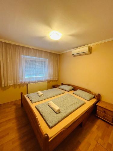 a bedroom with a bed with two pillows on it at Rose Vip Apartman in Hajdúszoboszló