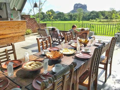 a wooden table with food on top of a patio at Kashyapa Kingdom View Home in Sigiriya