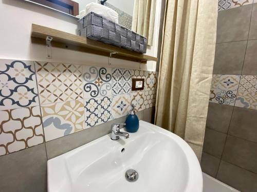 La salle de bains est pourvue d'un lavabo blanc et d'une douche. dans l'établissement Casa Labi, à Termini Imerese