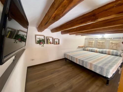 - une chambre avec un lit dans une pièce dotée de plafonds en bois dans l'établissement Casa Labi, à Termini Imerese