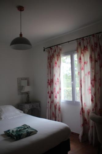 a bedroom with a bed and a window with curtains at Bastide Saint Bernard in Le Thoronet