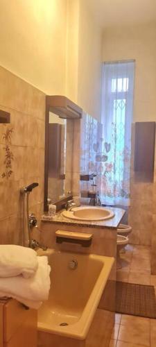 a bathroom with a sink and a toilet and a mirror at Grandmother's House style vintage anni '70 e '80 in Milan