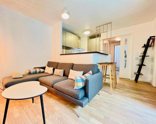 a living room with a couch and a table at Appartement de Standing Aux Portes de Paris in Nogent-sur-Marne