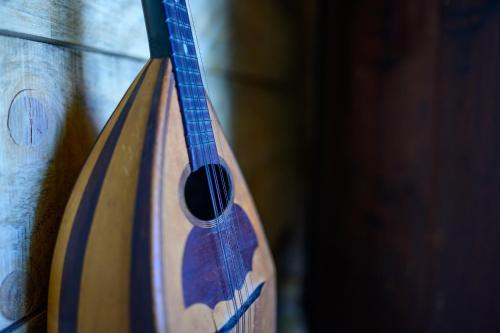 a wooden acoustic guitar sitting on a wall at Villa Vanille in Boisseron