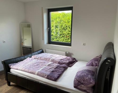 a bed in a room with a window at Bungalow mit großem Garten uneinsehbar und Stellplatz in Landshut