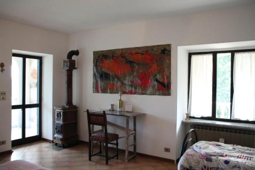 a bedroom with a table and a painting on the wall at Antica Dimora del Portico in Borgiallo