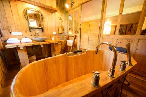 a wooden bathroom with a tub and a sink at Villa Vanille in Boisseron