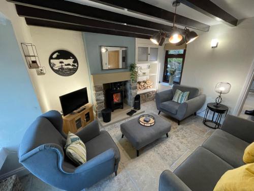 a living room with two couches and a fireplace at Muddy Paws Cottages - The Nook in Taddington