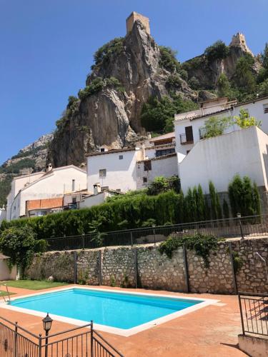 uma piscina em frente a uma montanha em Apartamento con vistas a la piscina y al castillo templario em La Iruela