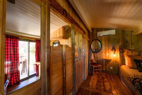 a room with wooden walls and a bed and a window at Villa Vanille in Boisseron