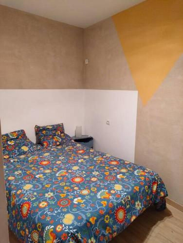 une chambre avec un lit avec une couette colorée dans l'établissement Appartement centre ville rose, à Toulouse