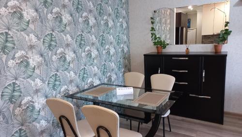 a dining room with a glass table and chairs at NG Cozy App in Tbilisi City
