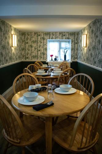 Un comedor con mesa y sillas de madera. en Littlewell Farm, en Wells