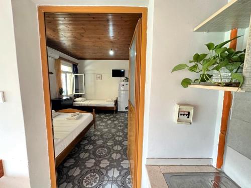 a hallway leading to a room with a bed and a bathroom at Boungainvillea in Himare