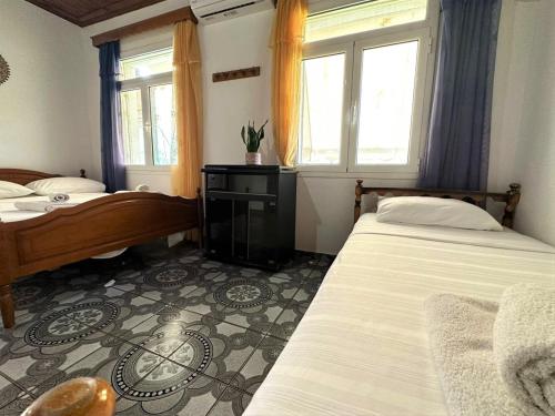 a bedroom with two beds and a window at Boungainvillea in Himare