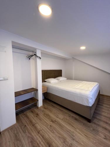 a bedroom with a large bed and wooden floors at Zani Boutique Hotel in Prizren
