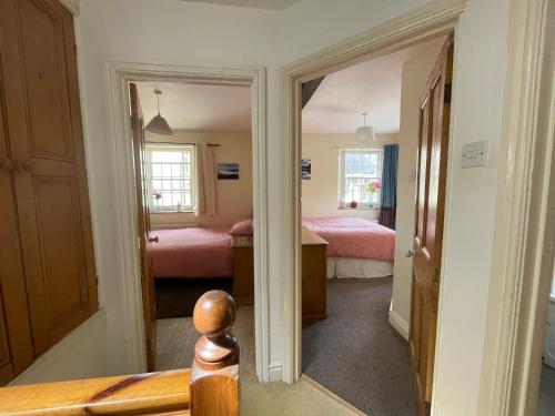 a room with two beds and a door to a bedroom at Robinsons Cottage, central and quiet in Cockermouth