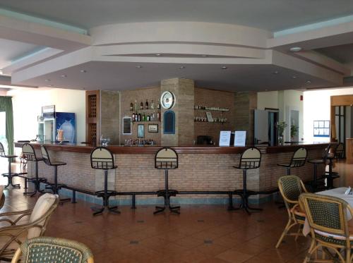 a bar in a restaurant with a clock on the wall at Pylea Beach Hotel in Ialysos
