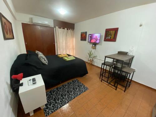 Schlafzimmer mit einem Bett, einem Tisch und einem Schreibtisch in der Unterkunft Hermoso Monoambiente en Nva Cordoba in Cordoba