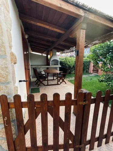 a wooden fence in front of a patio with a table at BeFree Apartments Viddalba in Lu Razzoni