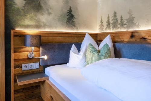 a bedroom with a large white bed with a headboard at Hotel zur Post in Ruhpolding