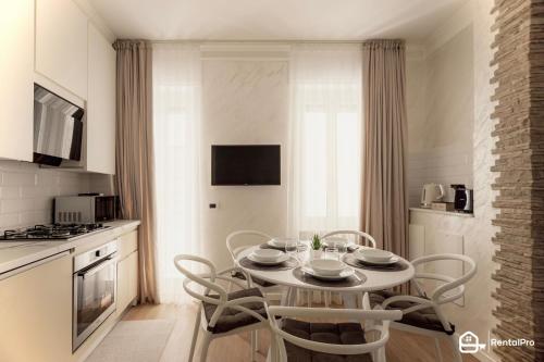 uma cozinha com mesa e cadeiras num quarto em [Ariston a 200m]-Luxury Apartment con A/C & Wi-Fi em Sanremo