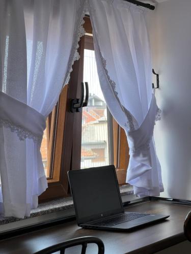 a laptop sitting on a desk in front of a window at Zani Boutique Hotel in Prizren
