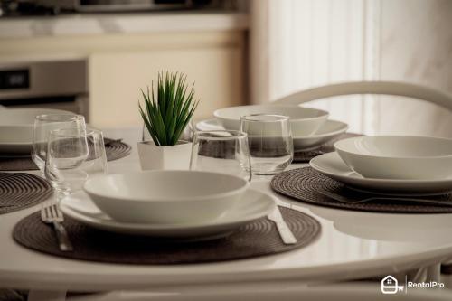 a table with plates and bowls and glasses on it at [Ariston a 200m]-Luxury Apartment con A/C & Wi-Fi in Sanremo