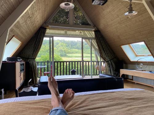 une personne dormant sur un lit dans une chambre avec fenêtre dans l'établissement Gîte piscine jacuzzi privatisés Clos Valentin, à Freulleville