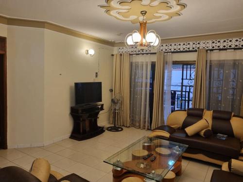 ein Wohnzimmer mit einem Sofa und einem Tisch in der Unterkunft Naalya Estate House in Kampala
