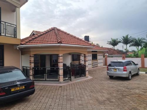 a house with two cars parked in a driveway at Naalya Estate House in Kampala