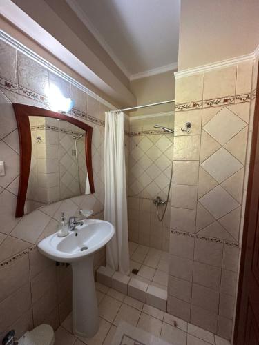 a bathroom with a sink and a shower at Nisos family apartments in Yénion