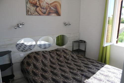 - une chambre avec un lit et 3 miroirs sur le mur dans l'établissement Villa 19, Port Vénus au village naturiste, au Cap d'Agde