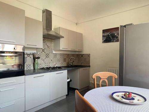 - une cuisine avec une table et une plaque de cuisson dans l'établissement Appartement dans maison Chomérac, à Chomérac