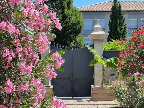 ChoméracにあるAppartement dans maison Choméracの家の前のピンクの花の青い門