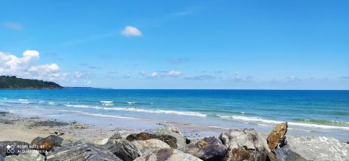 a beach with some rocks and the ocean at APPARTEMENT 100 Metres de la mer in Plérin