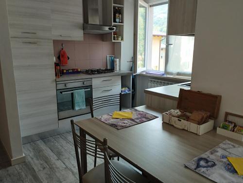 a kitchen with a wooden table and a counter top at Appartamento Miro in San Pellegrino Terme