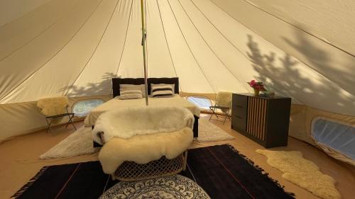Intsu Royal Kadakametsa Glämp في Liiva: غرفة نوم بسرير في خيمة