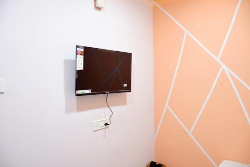 telewizor z płaskim ekranem wiszący na ścianie w obiekcie sun guest house w mieście Ujjain