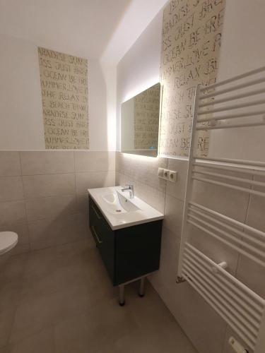 Baño blanco con lavabo y espejo en FeWo-Solveig, en Putgarten