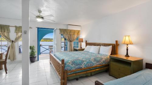 a bedroom with a bed and a balcony at Edwards Guesthouse in Sandy Ground Village