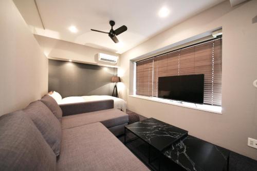 a living room with a couch and a tv at ZONK HOTEL Nakasu in Fukuoka