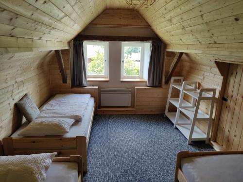 a small room with two beds and a window at Chalupa v Okrouhlé Radouni in Okrouhlá Radouň
