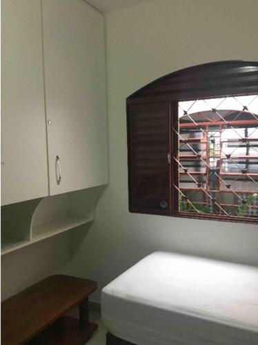 een keuken met een raam en een witte kast bij Se hospede na casa da Márcia in Jundiaí