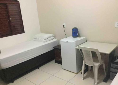 a small room with a desk and a bed and a table at Se hospede na casa da Márcia in Jundiaí