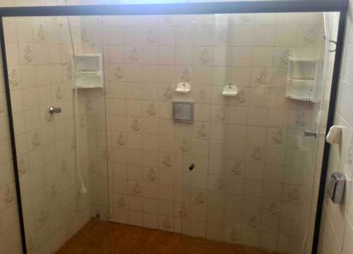 y baño con ducha de azulejos blancos. en Se hospede na casa da Márcia, en Jundiaí