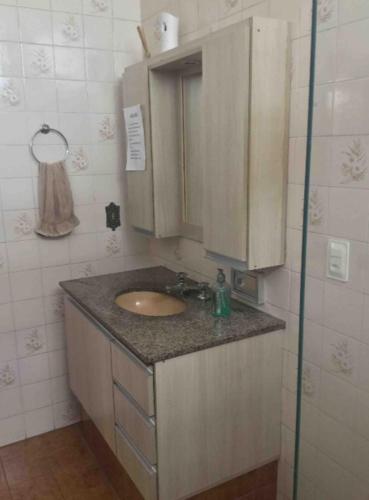 W łazience znajduje się umywalka i lustro. w obiekcie Se hospede na casa da Márcia w mieście Jundiaí